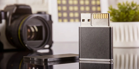 An SD card to USB adapter for fast transfers next to a camera.