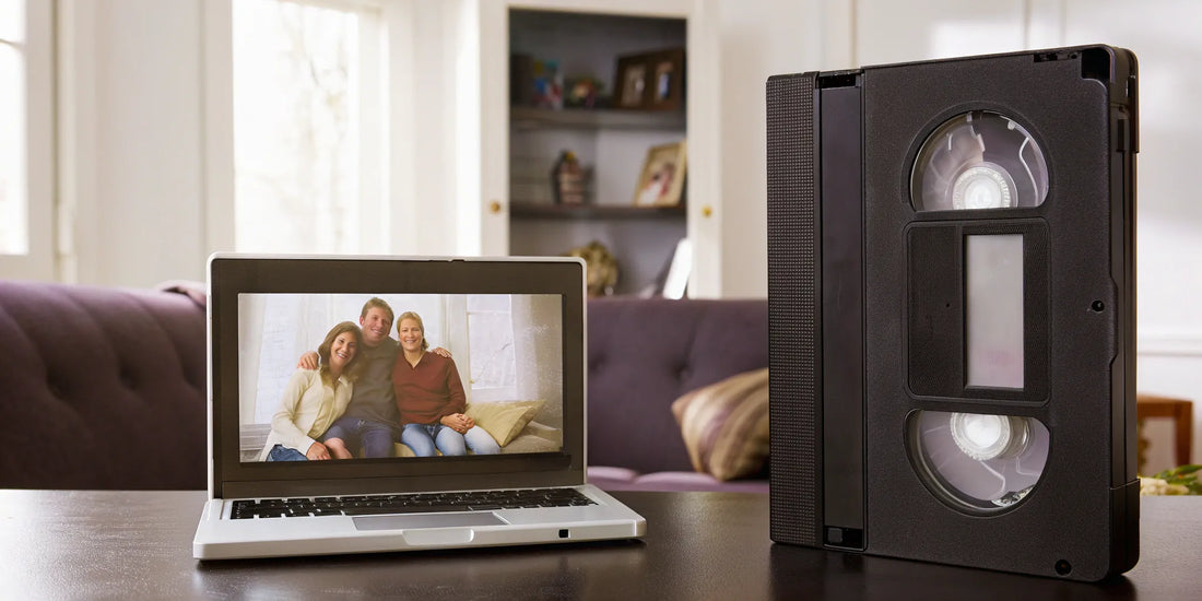 VHS-C tape next to a laptop displaying family photos.