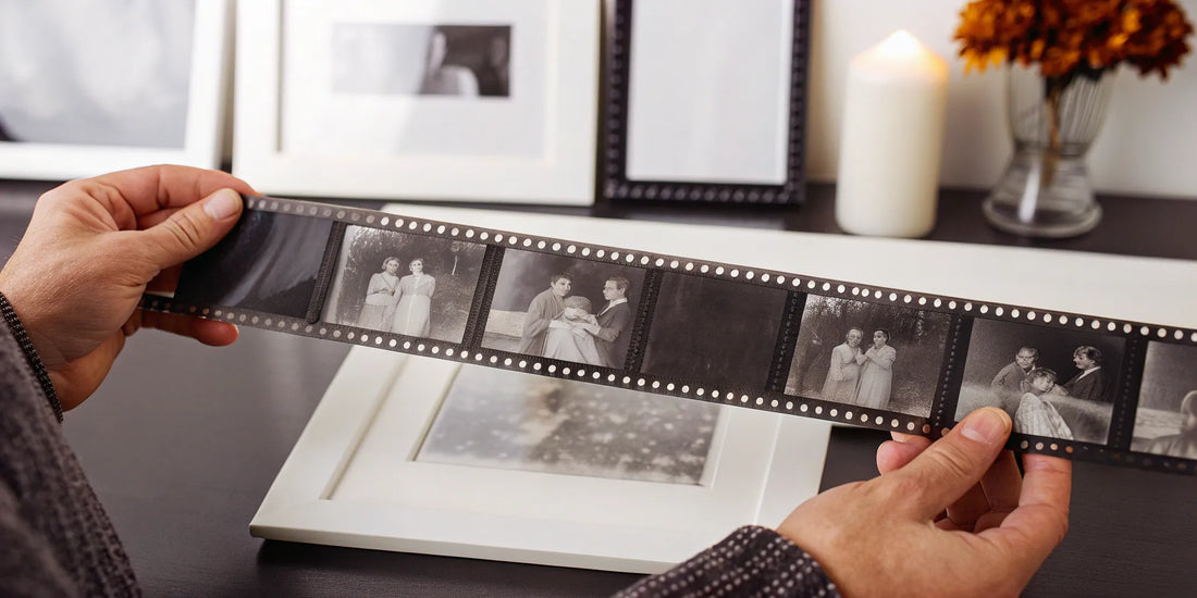 A strip of 35mm negatives being carefully handled for preservation and scanning.