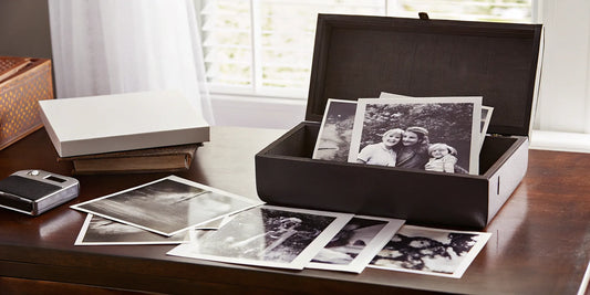 Old printed photos in a box ready for digital scanning.