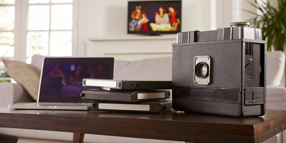 A laptop showing what an MP4 format is, surrounded by vintage video tapes.