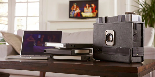 A laptop showing what an MP4 format is, surrounded by vintage video tapes.