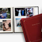 Open family photo albums with printed pictures stacked on a white background